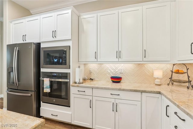 kitchen featuring appliances with stainless steel finishes, backsplash, and white cabinetry