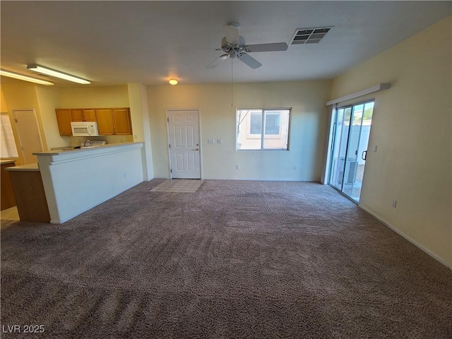 unfurnished living room with ceiling fan and carpet flooring