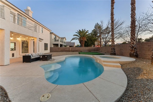 pool at dusk featuring an in ground hot tub, an outdoor living space, and a patio area