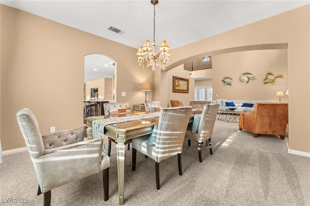 carpeted dining space featuring a chandelier