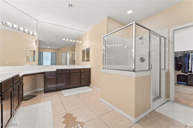 bathroom featuring tile patterned flooring, vanity, and walk in shower