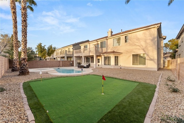 back of house with a balcony, a fenced in pool, and a patio