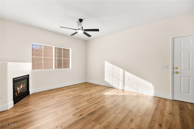 unfurnished living room featuring ceiling fan and light hardwood / wood-style flooring