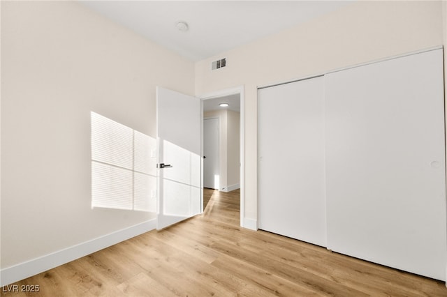 unfurnished bedroom featuring light hardwood / wood-style floors and a closet