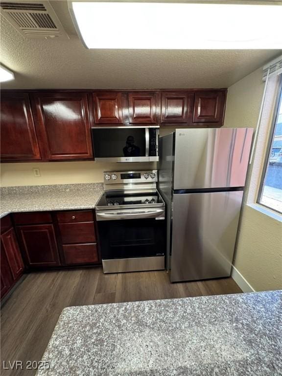 kitchen featuring appliances with stainless steel finishes and dark hardwood / wood-style floors