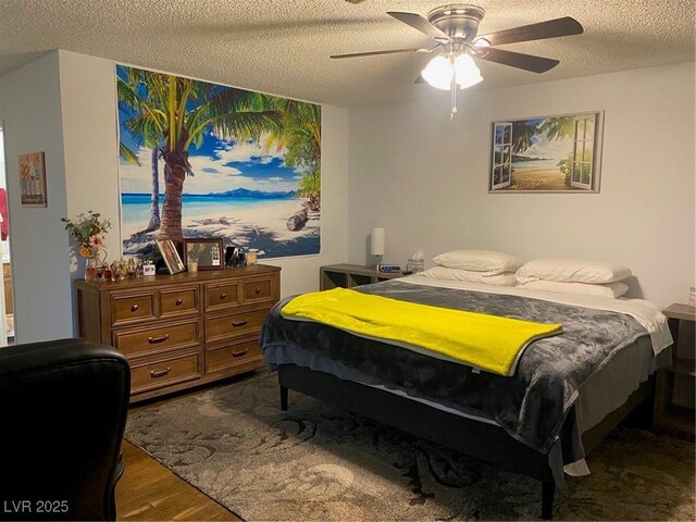 bedroom featuring ceiling fan, hardwood / wood-style floors, and a textured ceiling