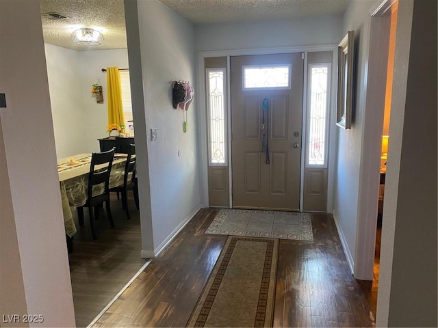 entryway with dark hardwood / wood-style floors and a textured ceiling