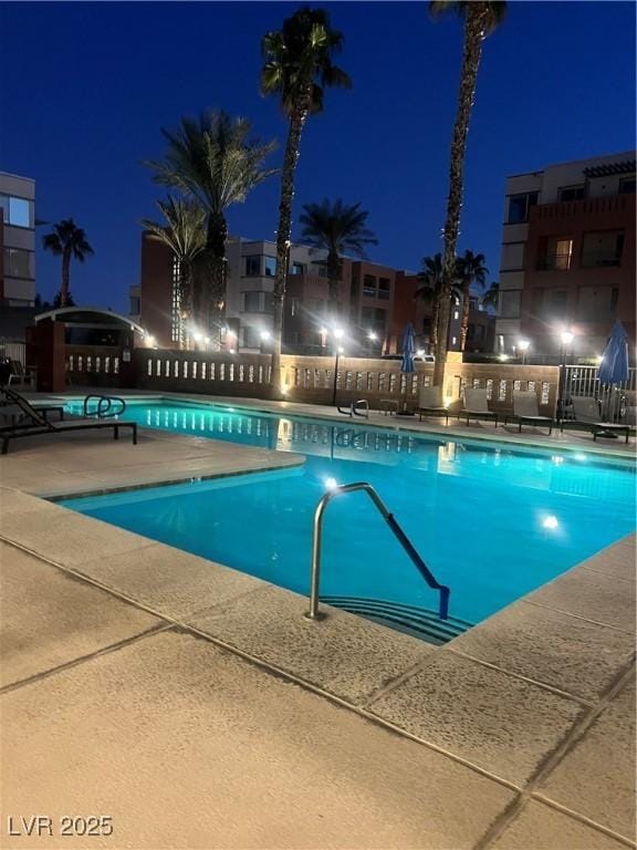 view of pool at twilight