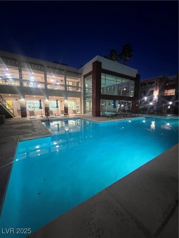 view of pool at twilight