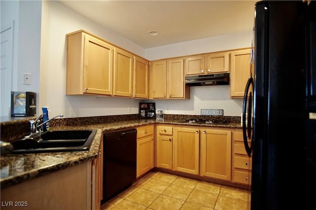 kitchen featuring sink, light tile patterned floors, light brown cabinets, dark stone counters, and black appliances