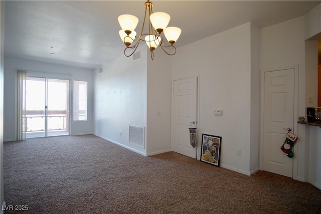 spare room featuring an inviting chandelier and carpet