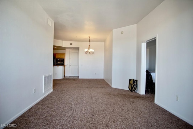 unfurnished room with carpet flooring and a chandelier