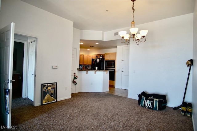 kitchen with pendant lighting, a breakfast bar area, dark colored carpet, black appliances, and a chandelier