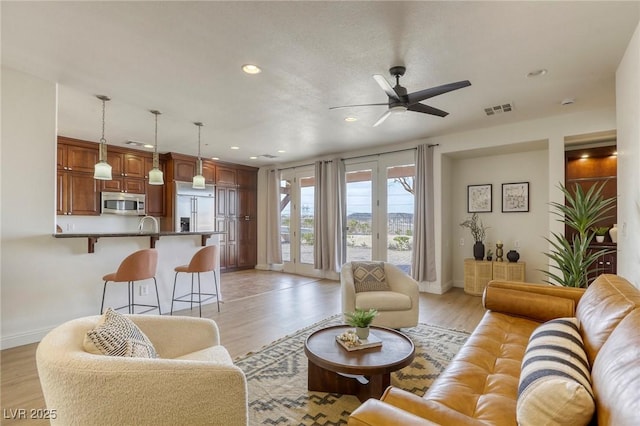 living room with ceiling fan and light hardwood / wood-style floors