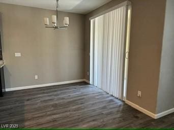 unfurnished dining area with dark wood-type flooring and an inviting chandelier