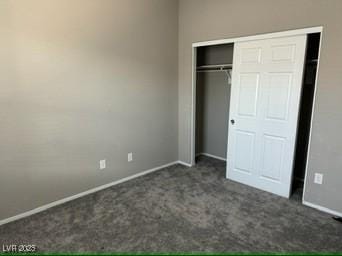 unfurnished bedroom featuring a closet and dark colored carpet