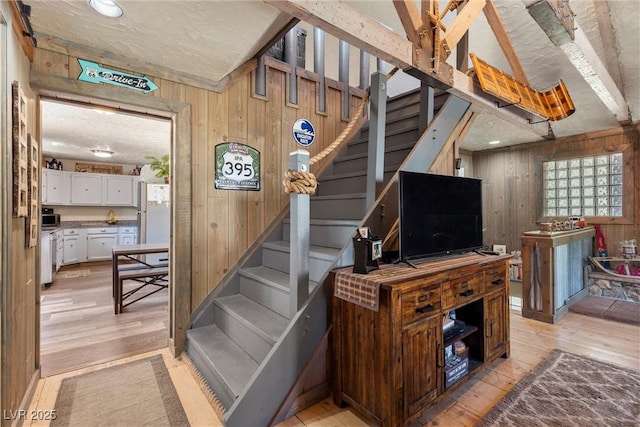 stairway featuring hardwood / wood-style floors and wooden walls