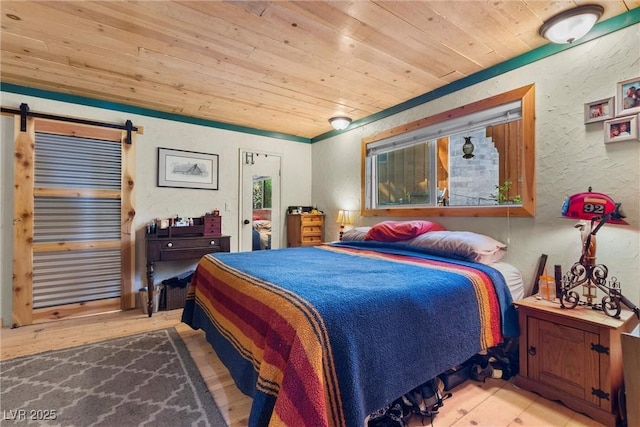 bedroom with a barn door and wooden ceiling