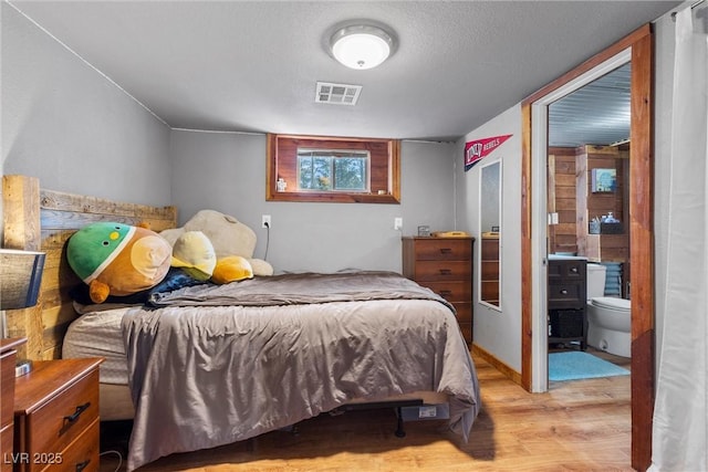 bedroom featuring light hardwood / wood-style floors and connected bathroom