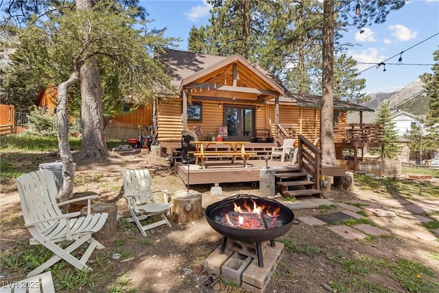 back of house featuring a deck and a fire pit