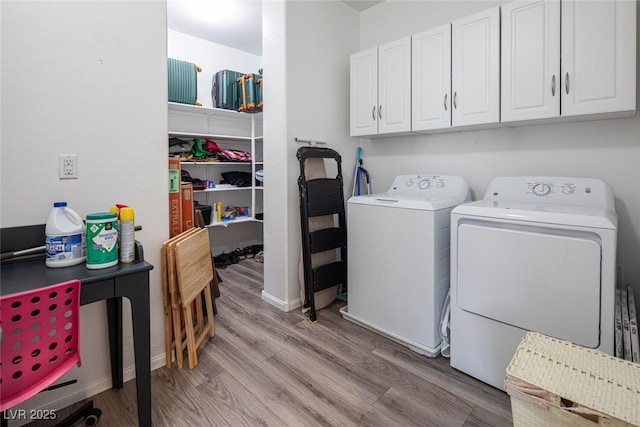 washroom with cabinets, light hardwood / wood-style flooring, and washing machine and dryer