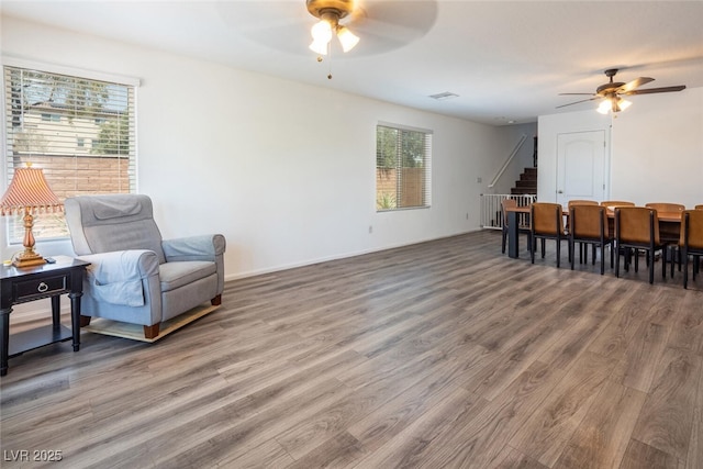 sitting room featuring ceiling fan, hardwood / wood-style floors, and a healthy amount of sunlight