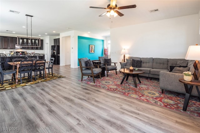 living room featuring ceiling fan and light wood-type flooring