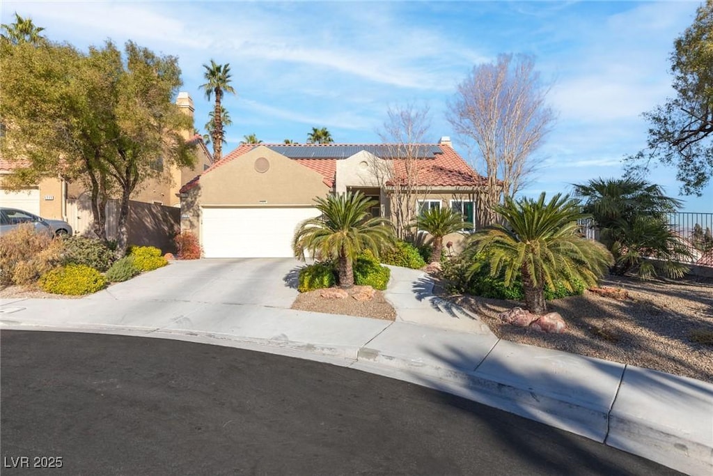 view of front of property with a garage and solar panels