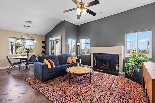 living room featuring ceiling fan, lofted ceiling, and dark tile patterned floors