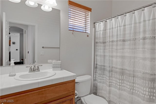 bathroom with toilet, a shower with curtain, and vanity