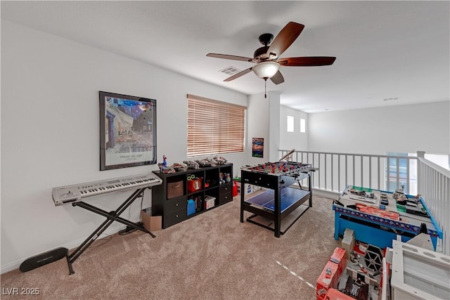 recreation room with ceiling fan and carpet