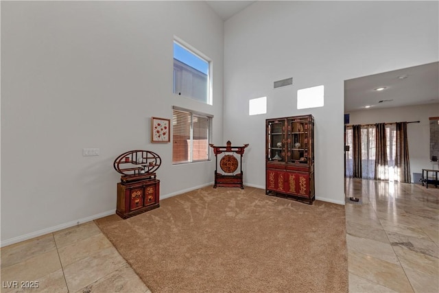 living area with light carpet and a high ceiling