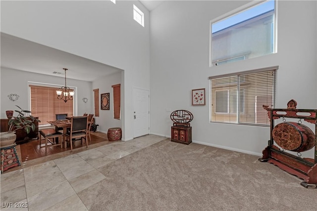 living room with a towering ceiling, light carpet, and a notable chandelier