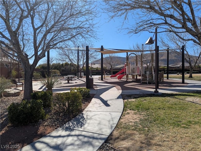 view of yard featuring a playground and a mountain view