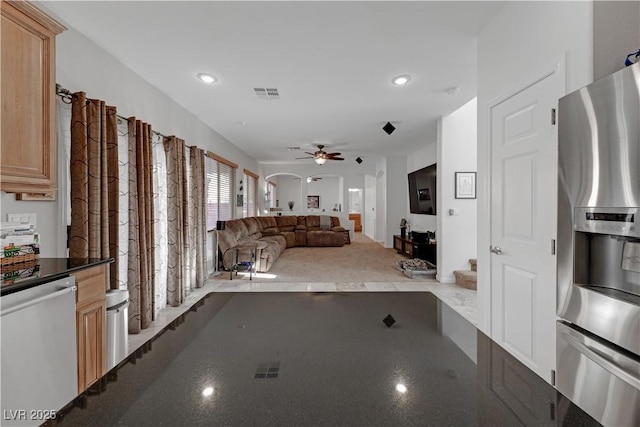 kitchen featuring ceiling fan, light brown cabinetry, appliances with stainless steel finishes, and dark stone counters