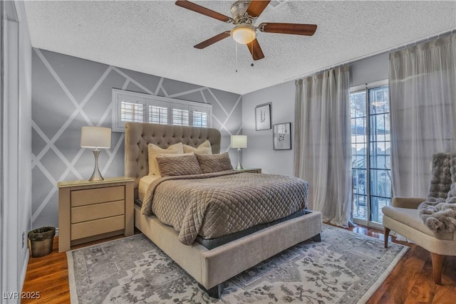 bedroom with ceiling fan, dark wood-type flooring, and a textured ceiling