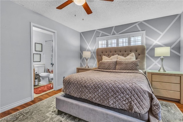 bedroom with hardwood / wood-style flooring, a textured ceiling, ensuite bath, and ceiling fan