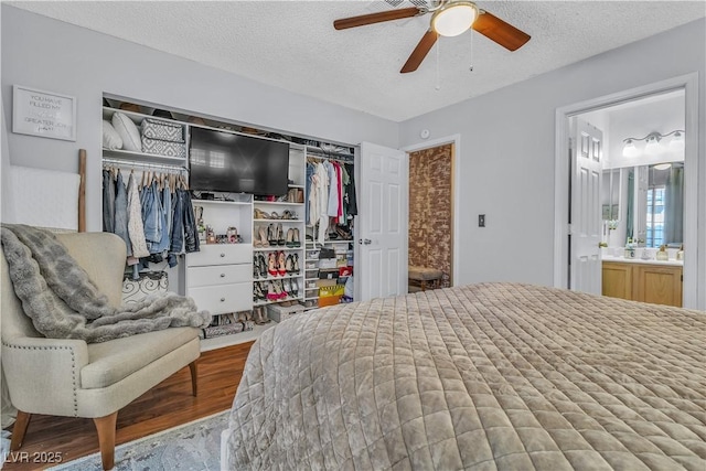 bedroom with a closet, ceiling fan, a textured ceiling, and ensuite bath