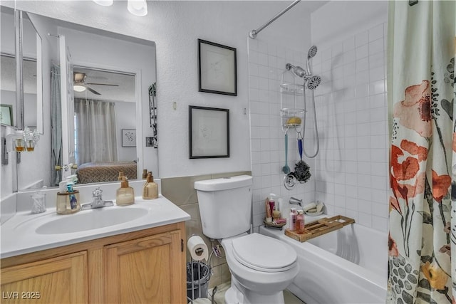 full bathroom featuring toilet, tile walls, shower / bath combo, vanity, and ceiling fan