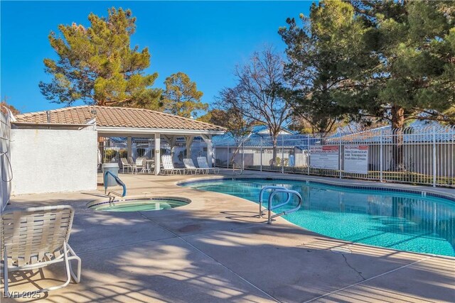 view of swimming pool featuring a patio and a hot tub