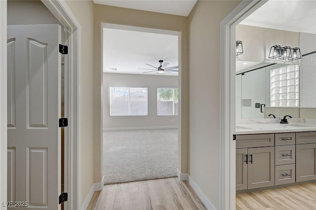 hallway with sink and light wood-type flooring