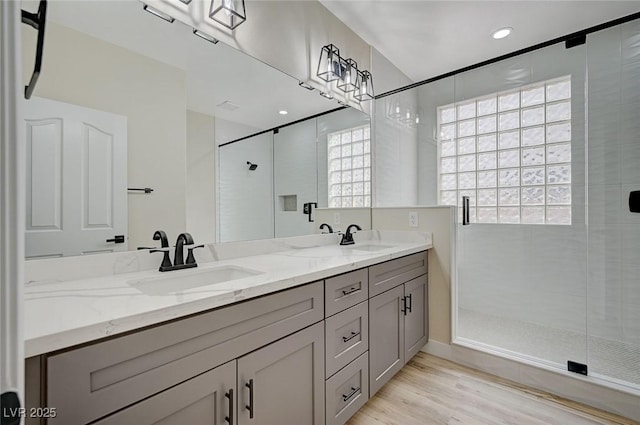 bathroom with hardwood / wood-style flooring, walk in shower, and vanity