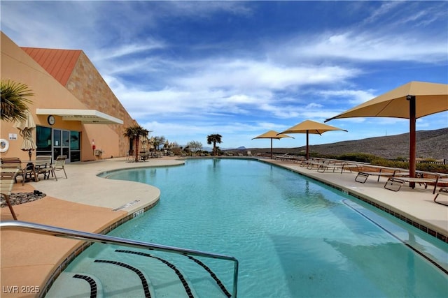 view of pool with a mountain view and a patio