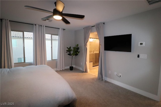 bedroom with ceiling fan, light colored carpet, and connected bathroom