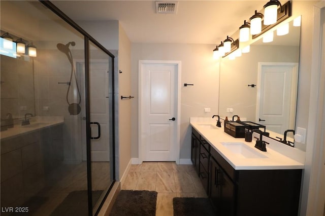 bathroom featuring a shower with shower door and vanity