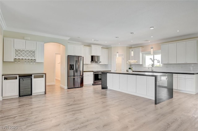 kitchen with light wood-type flooring, stainless steel appliances, beverage cooler, and white cabinets