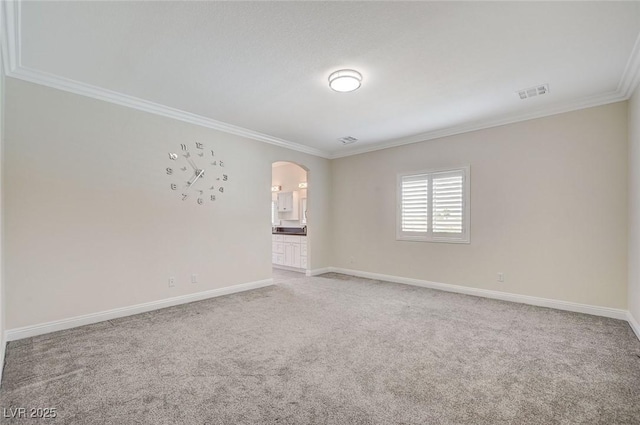 empty room featuring ornamental molding and carpet