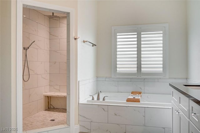 bathroom featuring vanity and independent shower and bath