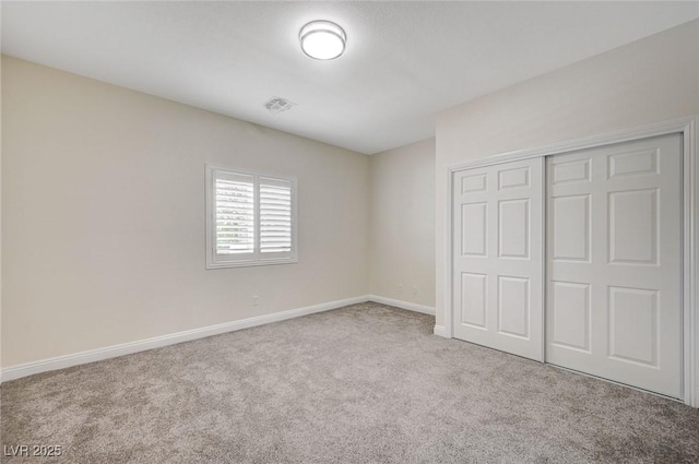 unfurnished bedroom featuring a closet and light carpet