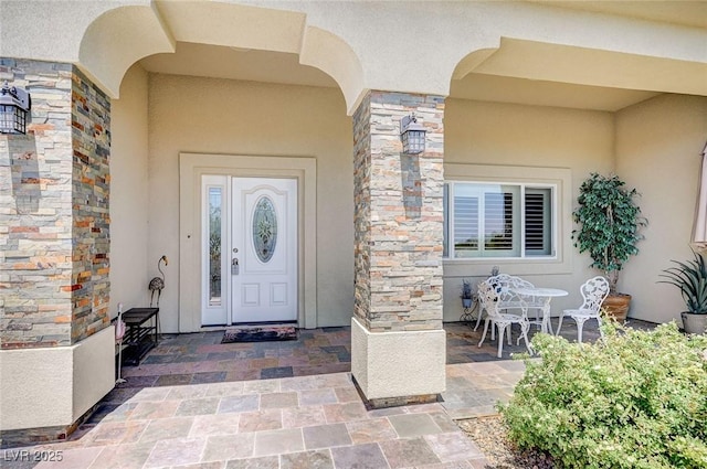 view of exterior entry with a patio area